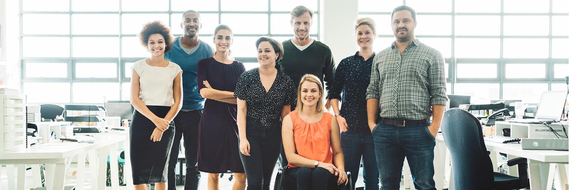 Diverse business people smiling in creative office.